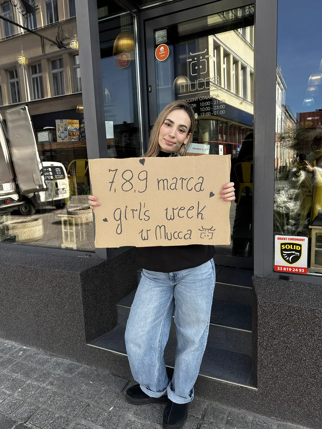 Klientka agencji WWH z tabliczką promującą girl's week w Mucca